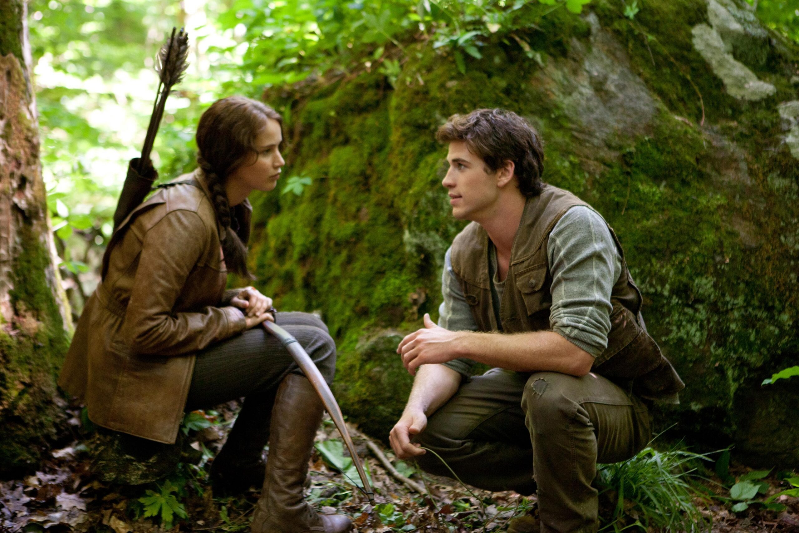 Scène dans la forêt. Katniss est assise avec son arc dans les main. Elle parle à son meilleur ami Kyle.
