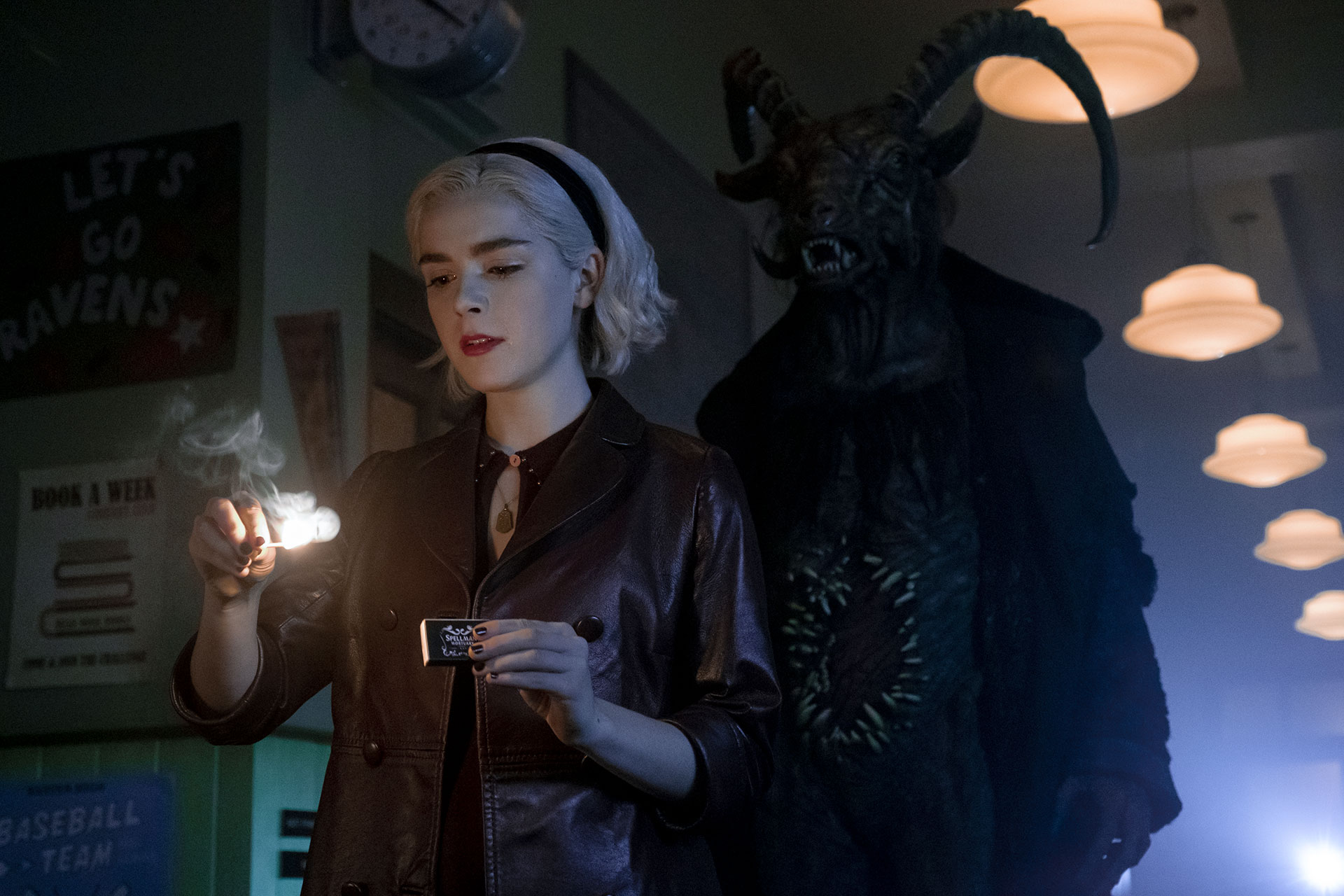 Sabrina craque une allumette alors que derrière elle, un démon apparait